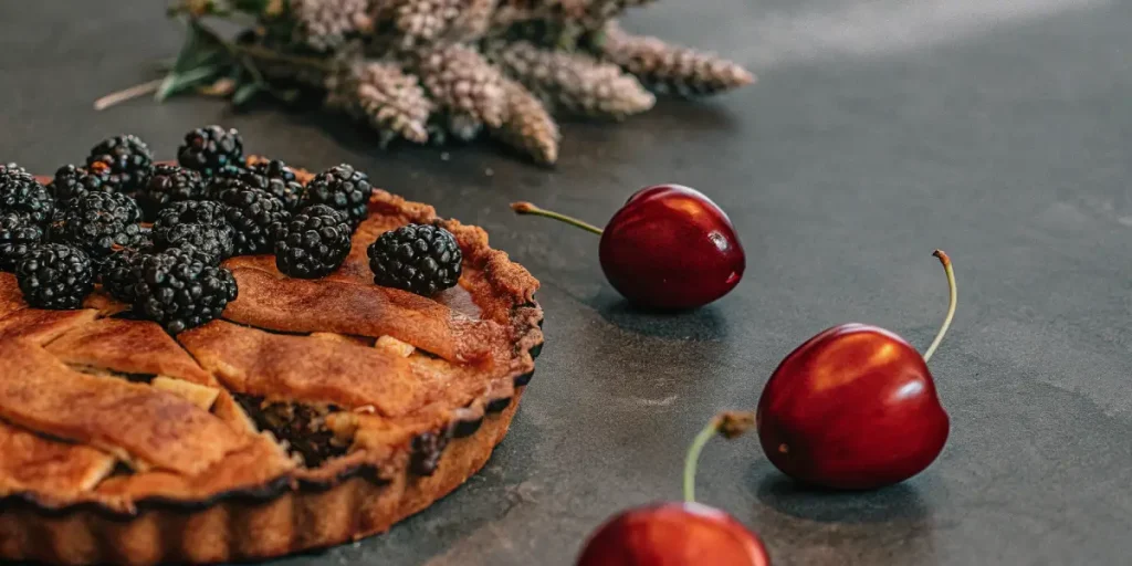 Blackberry Pie tart decorated with blackberries and cherries representing the strain’s fruity terpene notes