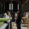 Des visiteurs explorent des présentations de produits à base de cannabis et échangent lors d’une grande exposition professionnelle.
