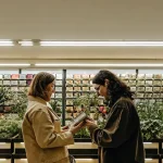 deux personnes examinent des paquets de graines dans un magasin de jardinage moderne.