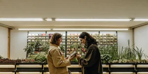 deux personnes examinent des paquets de graines dans un magasin de jardinage moderne.