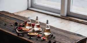 Flacons d’huiles essentielles de cannabis posés sur une table en bois rustique avec agrumes et fleurs séchées.