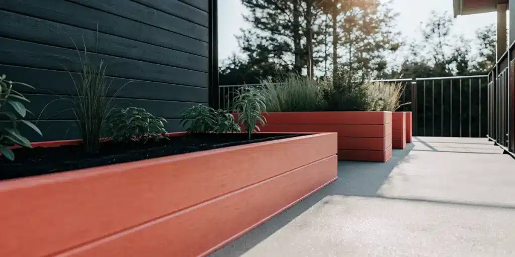 jardin extérieur avec plantes de cannabis dans des bacs en bois sur une terrasse ensoleillée.