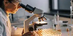 Scientifique analysant des échantillons de cannabis au microscope en laboratoire
