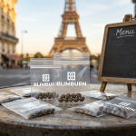 Graines de cannabis à Paris présentées sur une table de café avec des sachets Blimburn et la tour Eiffel en arrière-plan.