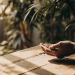 Main tenant des graines de cannabis sous lumière naturelle en intérieur